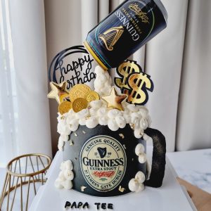 Guinness Beer mug illusion birthday cake with gravity pouring can, overflowing foam frosting and gold chocolate coins