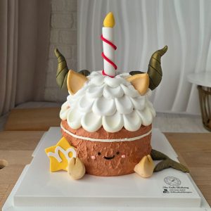 Capricorn Horoscope Jellycat Style Birthday Cake with textured brown cream, fluffy cream topping, fondant goat horns, smiling character face, candle topper, and Capricorn zodiac symbol by The Cake Alchemy Puchong Selangor
