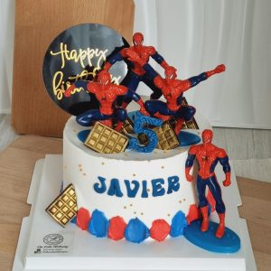 Spiderman themed birthday cake with superhero figurines, personalized name lettering, and red blue buttercream decorations by The Cake Alchemy in Puchong Selangor Malaysia