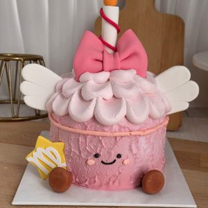 Virgo Horoscope Jellycat Style Birthday Cake with pastel pink textured cream, fluffy cream topping, fondant bow, angel wings, smiling character face, candle topper, and Virgo zodiac symbol by The Cake Alchemy Puchong Selangor