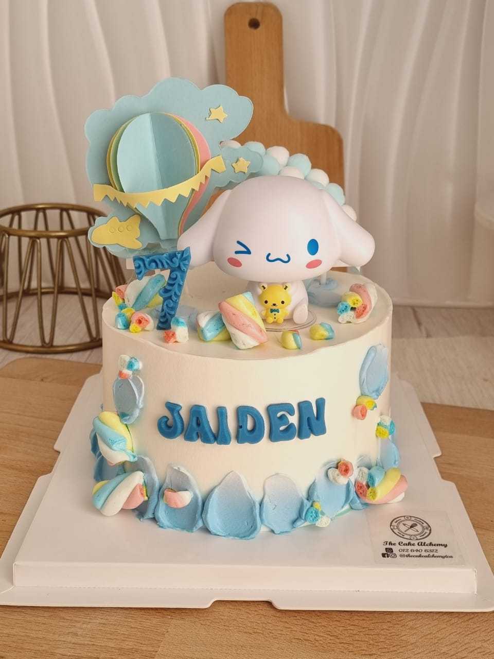 Cinnamoroll birthday cake with pastel blue cream, Sanrio character topper, rainbow decoration, and personalized name by The Cake Alchemy in Puchong Selangor Malaysia.