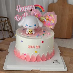 Cinnamoroll birthday cake with pastel pink cream, Sanrio character topper, rainbow decoration, and personalized name by The Cake Alchemy in Puchong Selangor Malaysia.
