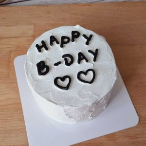Minimalist Happy B-Day cake with white cream frosting, handwritten black lettering, and heart decorations by The Cake Alchemy in Puchong Selangor Malaysia.