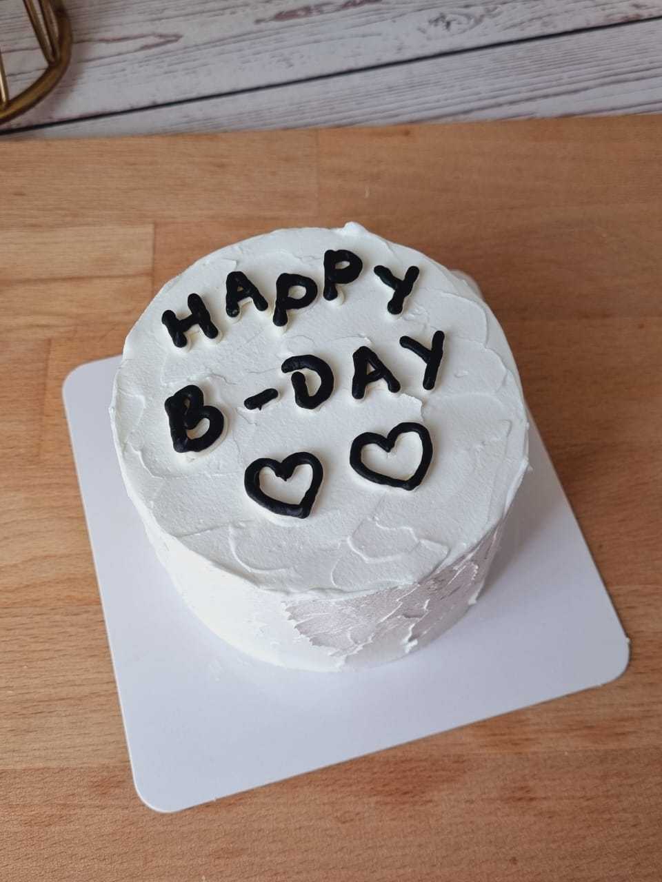 Minimalist Happy B-Day cake with white cream frosting, handwritten black lettering, and heart decorations by The Cake Alchemy in Puchong Selangor Malaysia.