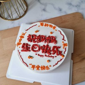Minimalist Chinese birthday cake with hand-piped Chinese birthday wishes, red and orange cream lettering, and small mandarin orange decorations by The Cake Alchemy in Puchong Selangor Malaysia.