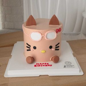 Ugly-cute kitty birthday cake with oversized glasses, pastel pink design, and Korean character style by The Cake Alchemy in Puchong Selangor Malaysia.