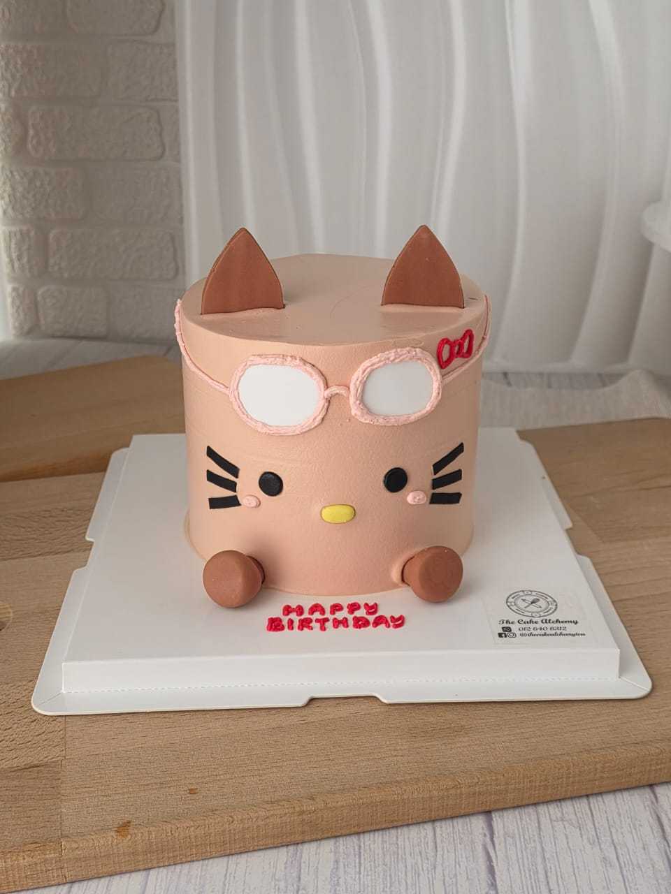 Ugly-cute kitty birthday cake with oversized glasses, pastel pink design, and Korean character style by The Cake Alchemy in Puchong Selangor Malaysia.