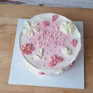 Pink buttercream flower birthday cake with handcrafted floral decorations, delicate petals, pearl accents, and personalized birthday message by The Cake Alchemy in Puchong Selangor Malaysia.