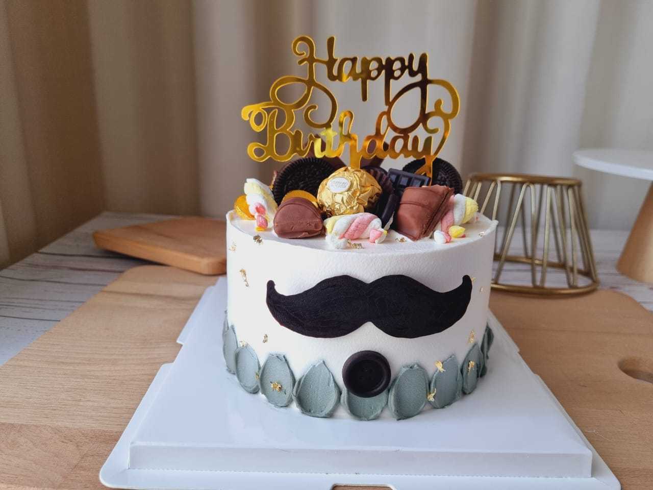 Moustache Dad birthday cake with chocolates, cookies, gold accents and Happy Birthday topper by The Cake Alchemy