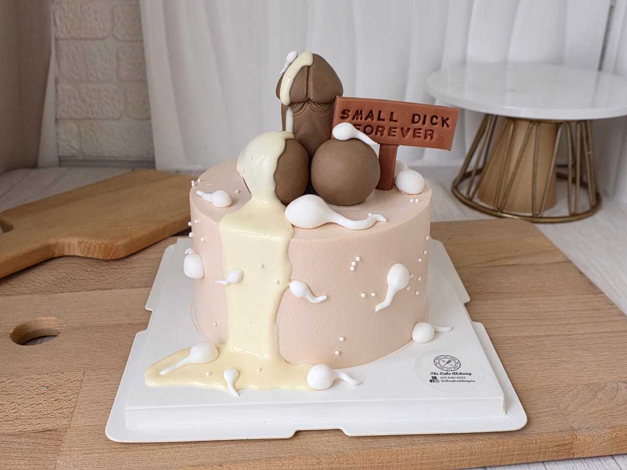 Funny adult birthday cake with cheeky 3D decorations, cream drip design, and humorous message plaque by The Cake Alchemy