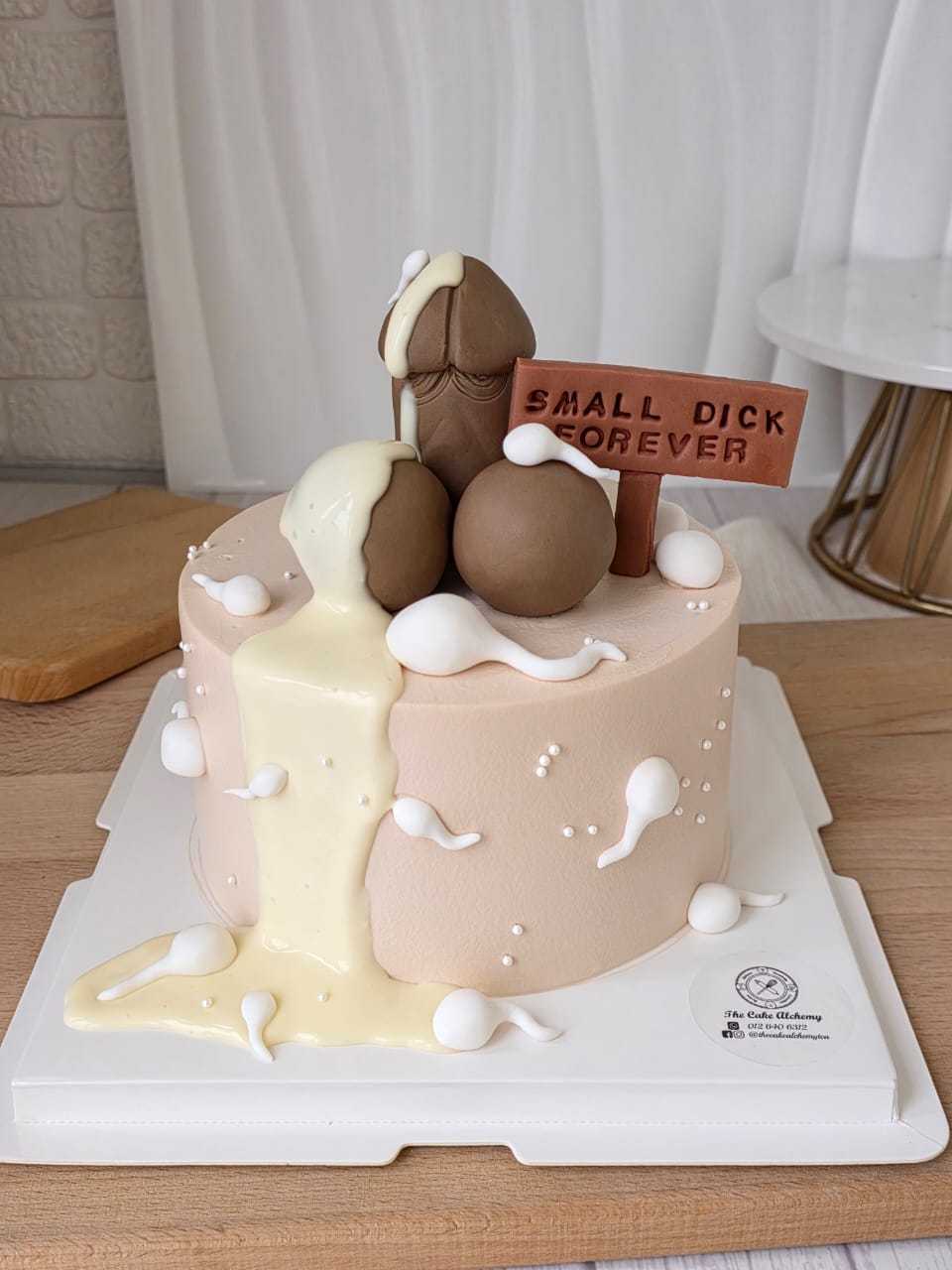 Funny adult birthday cake with cheeky 3D decorations, cream drip design, and humorous message plaque by The Cake Alchemy