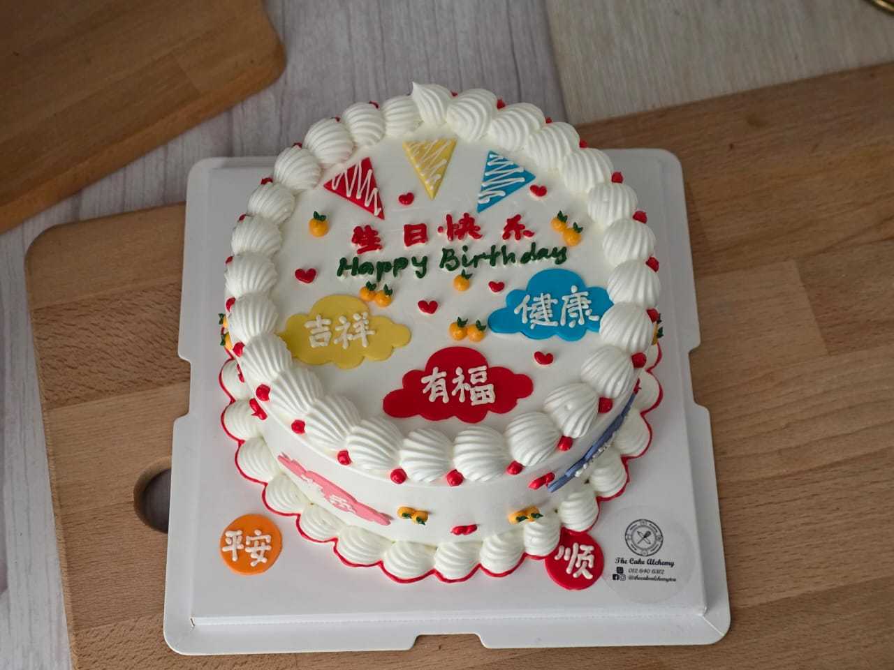 Chinese birthday cake with 吉祥, 健康, 有福 and 平安 blessing decorations, colourful details, and white cream piping by The Cake Alchemy